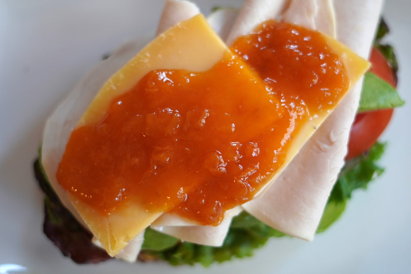 Apricot turkey generously spread on top of aged gouda on a turkey sandwhich